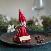 Lovi Elf Girl, bright red, wooden 3D puzzle, holding a nameplate on Christmas table