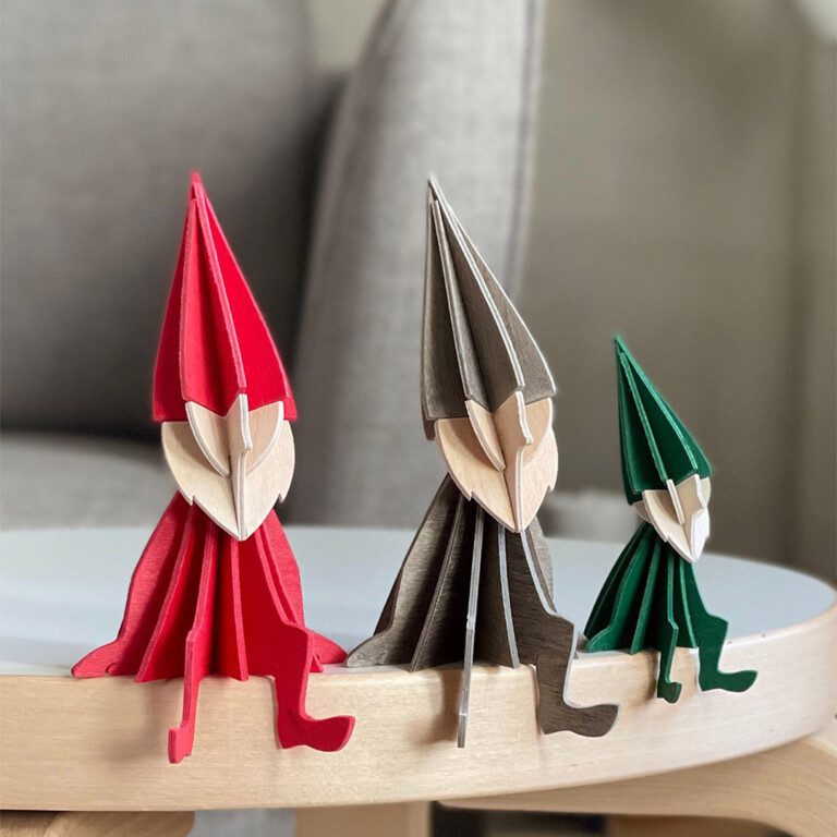 Lovi Elves sitting on a stool, wooden elf decorations, colors bright red, grey and dark green