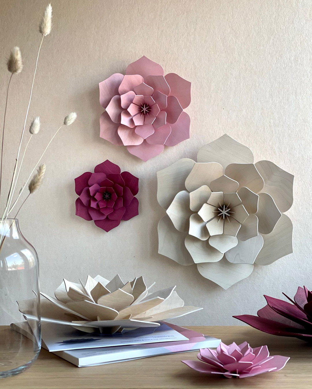 Lovi Decor Flowers on the wall and on table, sizes 48cm (natural wood), 34cm (light pink) and 24cm (dark red).