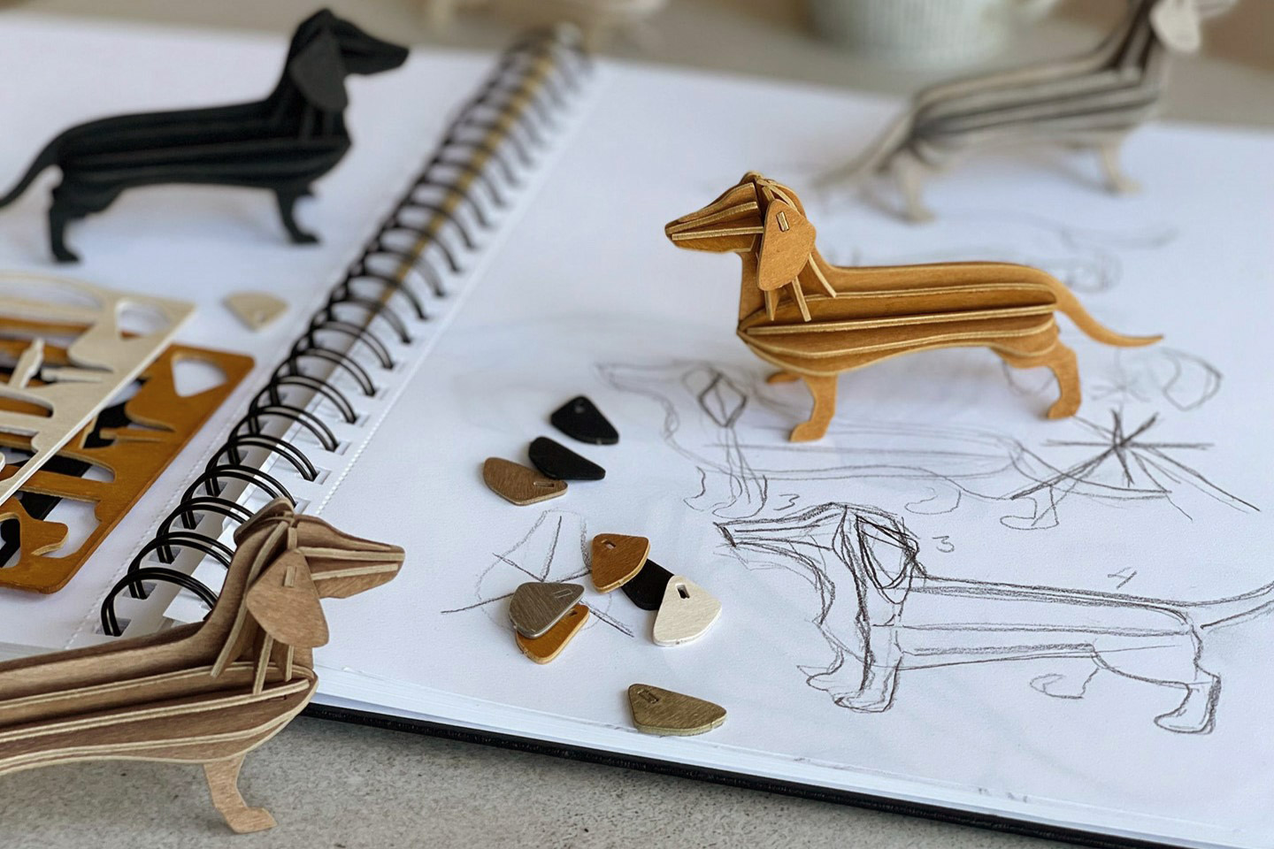 Lovi Dachshunds, wooden dachshund figures, on sketchbook.