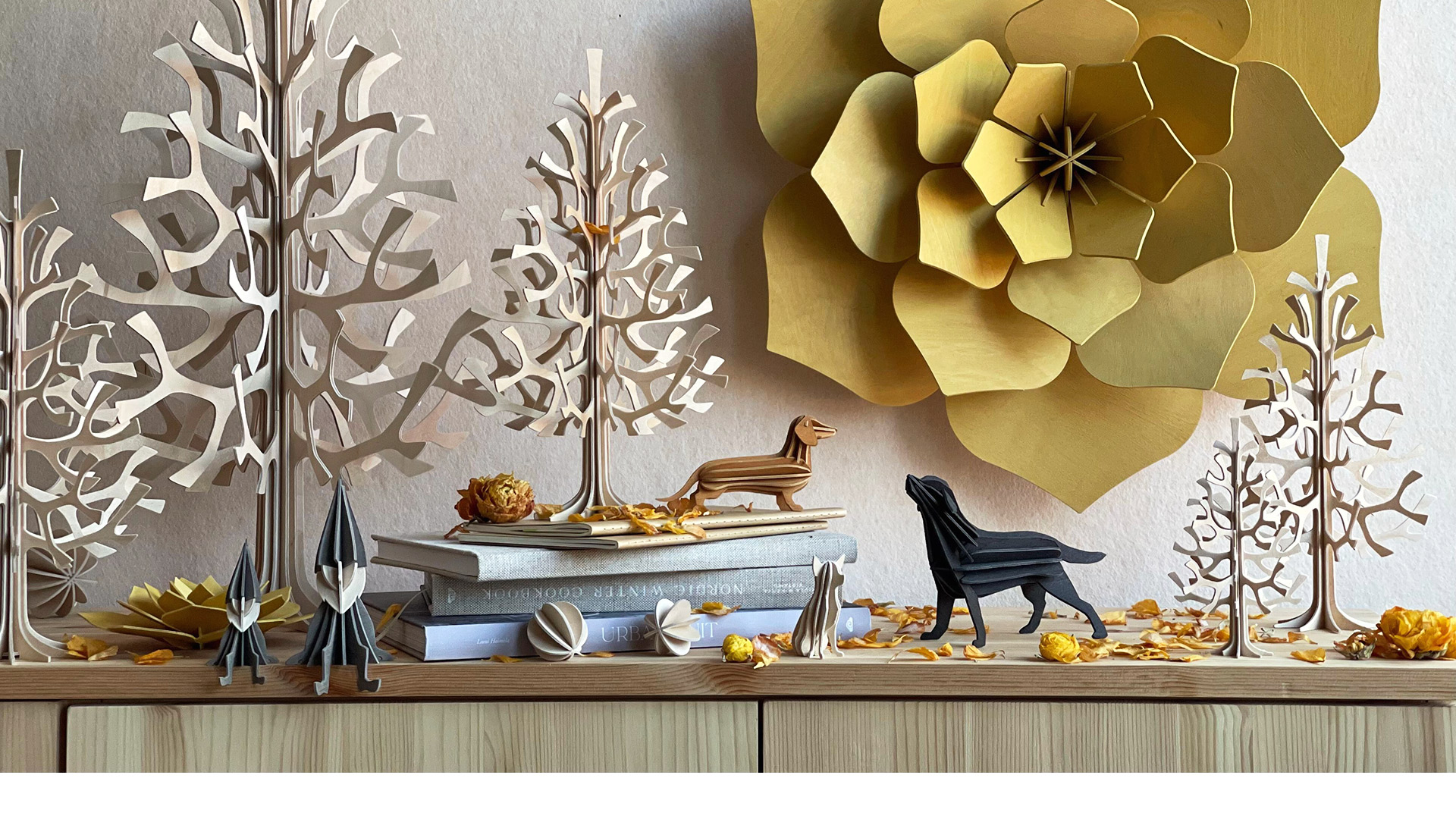 Wooden Lovi products on side table and on the wall, Lovi Spruces, Decor Flower, Elves and Dog figures