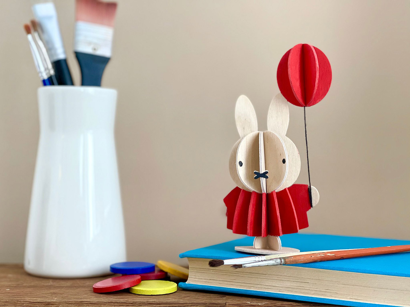 Lovin puinen Miffy ja ilmapallo -hahmo seisoo kirjan päällä. Maalattava Lovi-hahmo on luova ystävänpäivälahja.