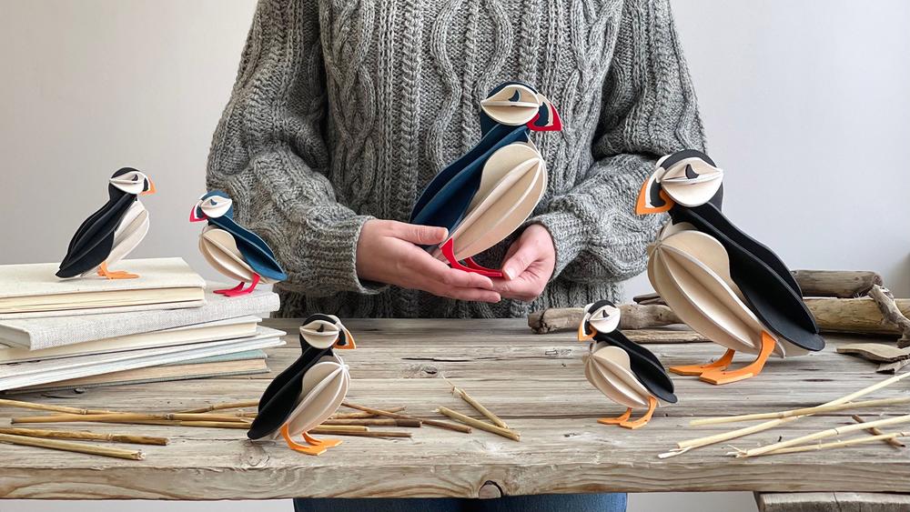 Wooden Lovi Puffins on old grey table, two colors, two sizes.